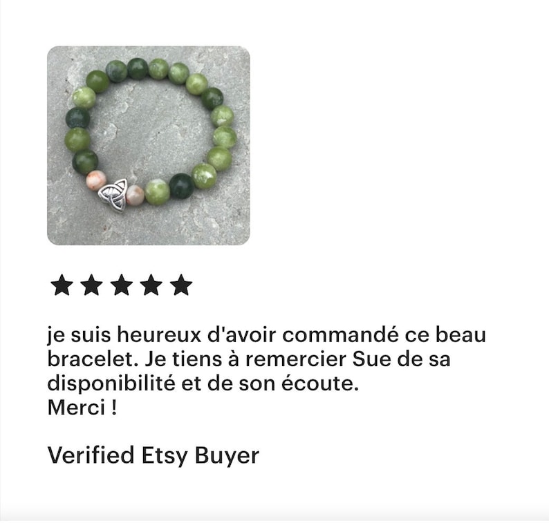May include: A green and brown beaded bracelet with a silver Celtic knot charm. The bracelet is on a gray background.