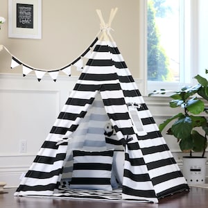 May include: Black and white striped teepee tent for kids with a white pillow and a small stuffed animal inside. The teepee is set up on a wooden floor.