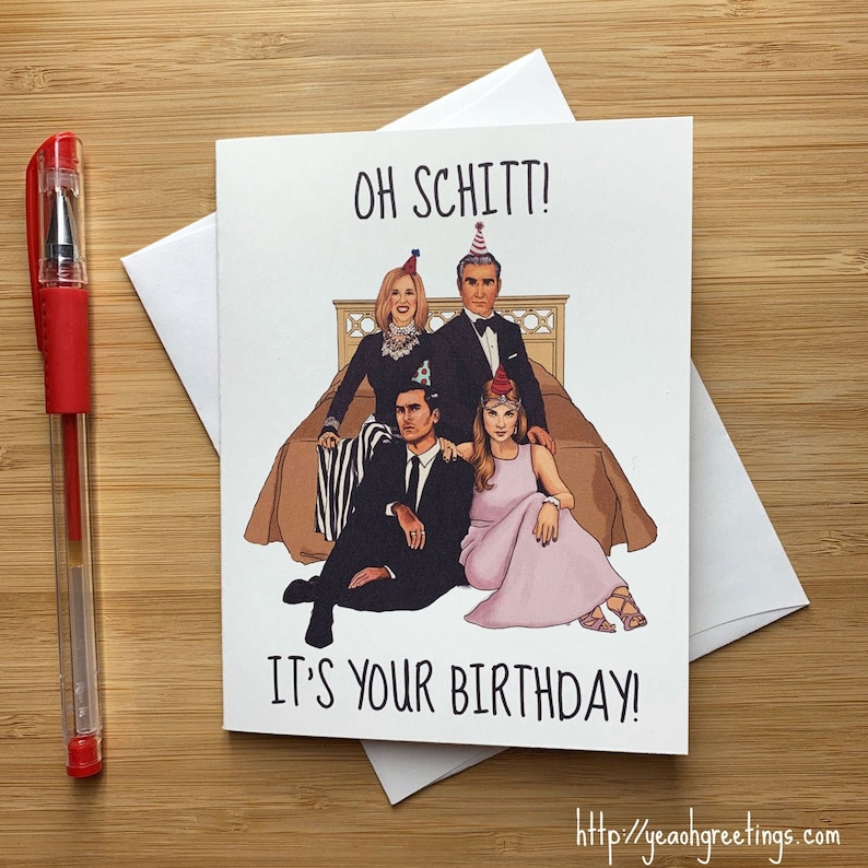 May include: A birthday card featuring a cartoon illustration of the cast of the TV show Schitt's Creek. The characters are wearing party hats and are sitting on a bed. The card reads "Oh Schitt! It's your birthday!"