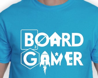 May include: A turquoise blue t-shirt with a white graphic that says "BOARD GAMER" with stylized icons representing board games.