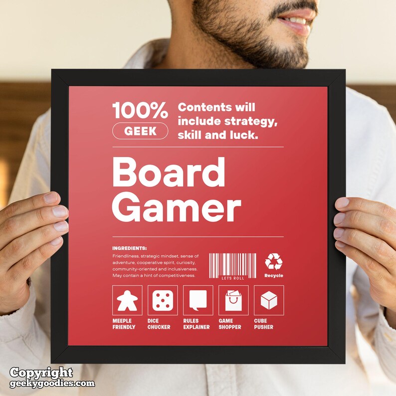 Pu&ograve; includere: Una stampa incorniciata con sfondo rosso e testo bianco che recita "Board Gamer". La stampa include il testo "100% I contenuti includeranno strategia, abilit&agrave; e fortuna" e icone di componenti di giochi da tavolo. La cornice &egrave; nera.