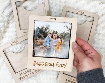 Könnte beinhalten: Holzbildrahmen mit einem Foto einer dreiköpfigen Familie. Der Rahmen hat einen Schlitz für ein Foto und Platz für eine Nachricht. Die Nachricht lautet "Best Dad Ever!" und "Happy Father's Day".