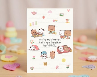 May include: A white card with a cute cartoon couple of bears. The text on the card reads "You're my forever. Let's age together beautifully."