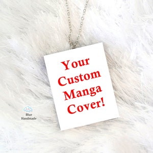 Puede incluir: Un colgante rectangular blanco con una cadena de plata. El colgante tiene el texto "Your Custom Manga Cover!" en letras rojas.