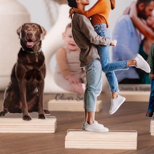May include: A set of personalized acrylic cutouts featuring a couple holding each other, a dog, and a family of six. The cutouts are on wooden bases and are ready to be displayed on a shelf or table.