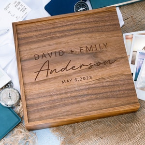 May include: A wooden box with a personalized inscription for a wedding. The inscription reads "David + Emily Anderson May 6, 2023".