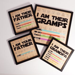 May include: Four framed art prints with black frames. The prints feature the phrases "I AM THEIR FATHER", "I AM YOUR FATHER", "I AM THEIR GRAMPS", and "I AM THEIR GRANDPA". Each print has a lightsaber design and character illustrations.