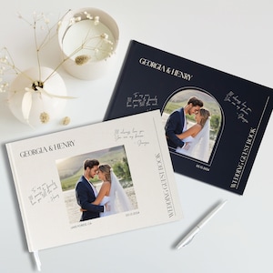 Puede incluir: Dos libros de invitados de boda blancos con una cubierta azul marino. Las cubiertas presentan una foto de la pareja y el texto "Georgia & Henry" y "Libro de invitados de la boda".