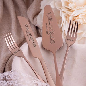 May include: A rose gold wedding cake serving set with a cake server, cake knife, and two forks. The cake server and knife are engraved with names and a date. The forks are engraved with initials.