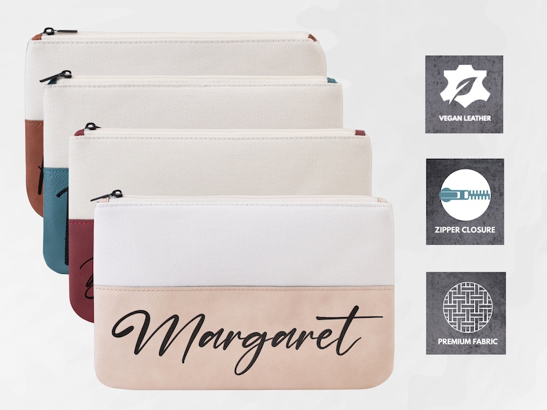 K&ouml;nnte beinhalten: Drei Rei&szlig;verschlusstaschen mit einem wei&szlig;en Canvas-Oberteil und einem Unterteil in verschiedenen Farben. Das Unterteil der Tasche vorne tr&auml;gt den Namen "Margaret" in schwarzer Schrift. Die Taschen sind aus veganem Leder und haben einen Rei&szlig;verschluss.