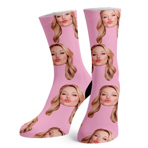 Puede incluir: Un par de calcetines rosas con un patr&oacute;n repetido de la cara de una mujer dando un beso. Los calcetines est&aacute;n hechos de un material suave y c&oacute;modo y son perfectos para el uso diario.