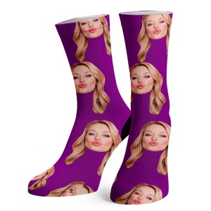 Puede incluir: Un par de calcetines morados con un patr&oacute;n repetido de la cara de una mujer haciendo una mueca.