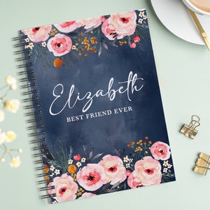 May include: A blue spiral bound notebook with a floral design and the text "Elizabeth Best Friend Ever" on the cover.