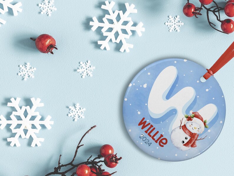 May include: A blue and white Christmas ornament with a snowman and the name "Willie" and the year "2024" written on it.