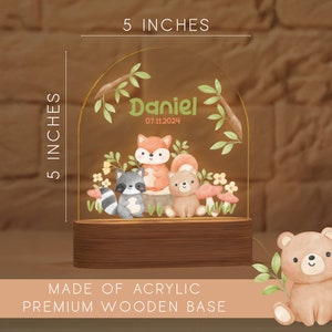 May include: A 5-inch tall acrylic night light with a premium wooden base. The design features a watercolor illustration of woodland animals, including a fox, raccoon, and bear, with the name "Daniel" and date.