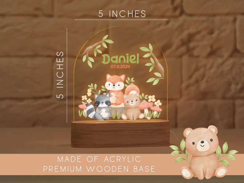 May include: A 5-inch tall acrylic night light with a premium wooden base. The design features a watercolor illustration of woodland animals, including a fox, raccoon, and bear, with the name "Daniel" and date.