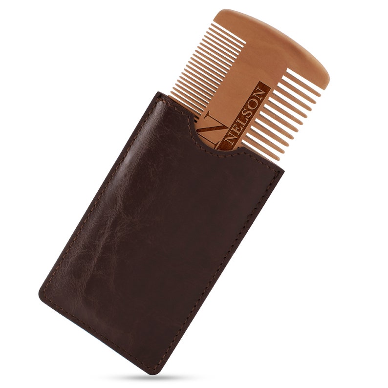 May include: A brown leather case with a wooden comb inside. The comb has the name "NELSON" engraved on it.