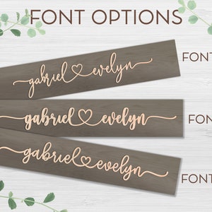 May include: Three wooden signs with different font styles showing the names "gabriel" and "evelyn" with a heart symbol between them. The signs are labeled "FONT 1", "FONT 2", and "FONT 3".
