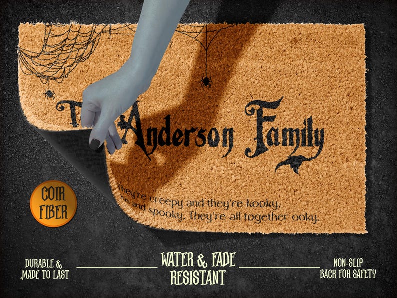 Pu&ograve; includere: Un tappetino per porta in fibra di cocco marrone con un design a ragnatela nero e il testo "Anderson Family" in un carattere gotico nero. Il testo sottostante recita "They're creepy and they're kooky, and spooky. They're all together ooky."