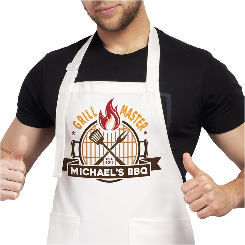 May include: White apron with a brown and orange grill master design. The design includes a grill, crossed grilling tools, flames, and the text "Grill Master" and "Michael's BBQ".