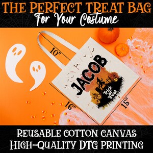 May include: A white canvas tote bag with a Halloween-themed design featuring a spooky forest scene, pumpkins, and the name "JACOB". The bag has black handles and measures 10 inches tall, 16 inches wide, and 15 inches deep.