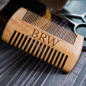 May include: A wooden comb with a natural finish and a BRW logo. The comb has a wide handle and fine teeth.