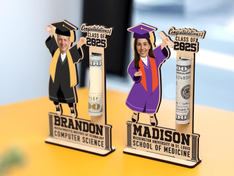 Op de afbeelding: Houten afstudeercadeau met twee figuren in afstudeerkleding, met diploma's. Elk figuur heeft een gleuf voor opgerolde bankbiljetten. De bases lezen "BRANDON COMPUTER SCIENCE" en "MADISON SCHOOL OF MEDICINE" met "CLASS OF 2025" erboven.