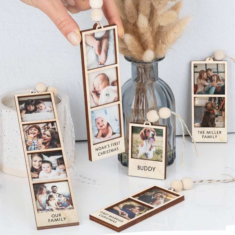 May include: Wooden photo ornaments with string for hanging.  The ornaments feature multiple photos in a vertical strip.  The text on the ornaments reads "Our Family", "Noah's First Christmas", "Buddy", "First Married Christmas", and "The Miller Family".