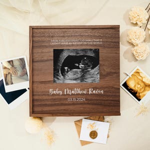 May include: A wooden keepsake box with a quote about leaving an imprint on the world. The box has a photo of an ultrasound image and the text "Baby Matthew Raven 03.15.2024".