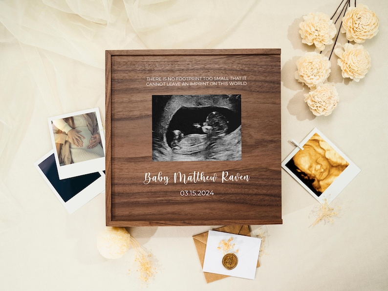 May include: A wooden keepsake box with a quote about leaving an imprint on the world. The box has a photo of an ultrasound image and the text "Baby Matthew Raven 03.15.2024".
