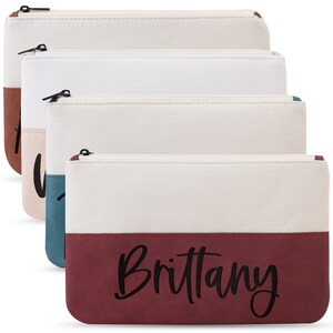 K&ouml;nnte beinhalten: Vier Rei&szlig;verschlusstaschen mit zweifarbigem Design. Die Taschen bestehen aus Canvas und Kunstleder. Die untere H&auml;lfte der Taschen ist in verschiedenen Farben gehalten: Braun, Rosa, T&uuml;rkis und Burgunderrot. Die burgunderrote Tasche tr&auml;gt den Namen "Brittany" in Schwarz auf der Vorderseite.