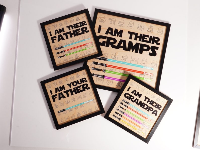 May include: Four framed art prints with black frames. The prints feature the phrases "I AM THEIR FATHER", "I AM YOUR FATHER", "I AM THEIR GRAMPS", and "I AM THEIR GRANDPA". Each print has a lightsaber design and character illustrations.