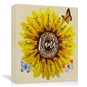 May include: A canvas print featuring a sunflower design with the word "Nana" in the center. The sunflower petals display names like Bella, Joseph, and Harper. Butterflies in orange and blue are scattered around the flower, creating a personalized and decorative piece.