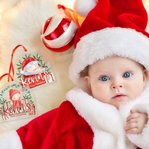 May include: Two clear acrylic Christmas ornaments featuring a watercolor illustration of a baby in a red hat, green holly, and the text Kevin's First Christmas 2024, each hanging from a thin red ribbon.