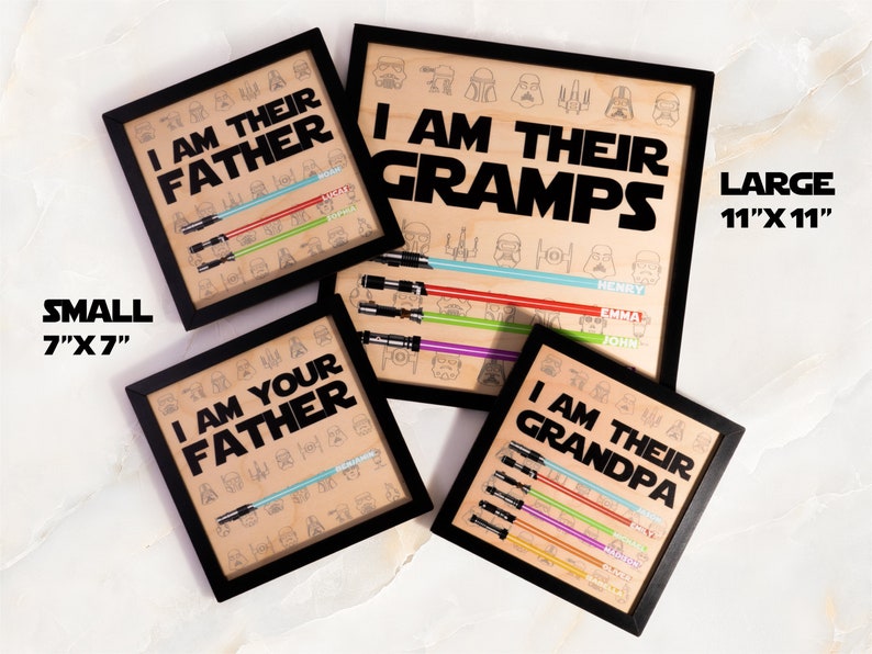 May include: Framed wooden art prints with black frames. The prints feature the phrases "I AM THEIR FATHER", "I AM THEIR GRAMPS", "I AM YOUR FATHER", and "I AM THEIR GRANDPA". Each print has a lightsaber design and names.