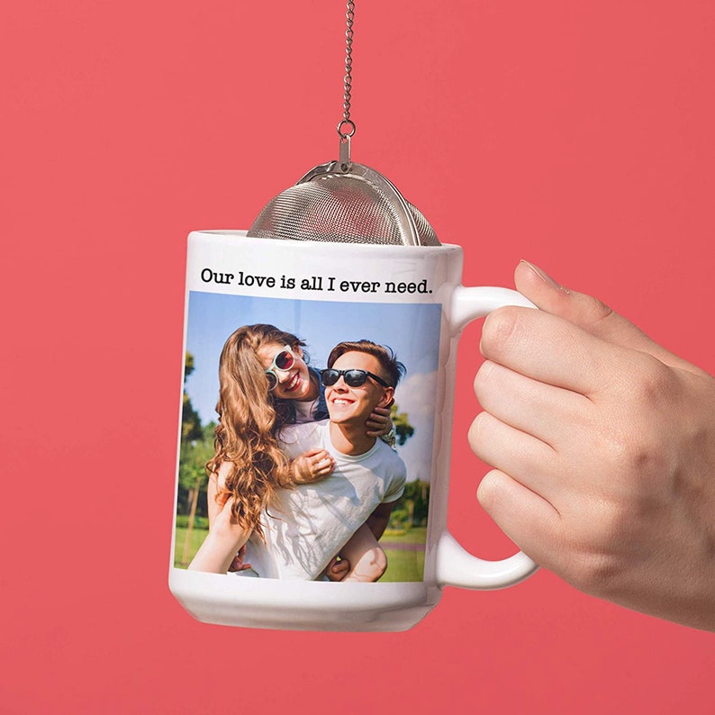 May include: White ceramic mug with a photo of a couple wearing sunglasses and the text "Our love is all I ever need."