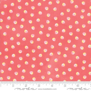 May include: Coral fabric with a repeating pattern of small, irregular white and yellow shapes. The fabric has a ruler along the bottom edge with the word "moda" printed on it.