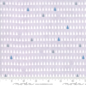 May include: A light purple fabric with a repeating pattern of white and blue Christmas trees. The trees are evenly spaced across the fabric. A ruler is at the bottom of the image, with the word "moda" printed on it.