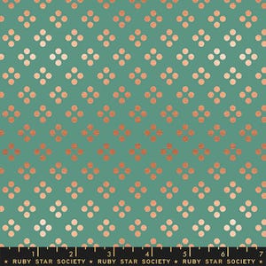 May include: A teal fabric featuring a repeating pattern of small, metallic copper-colored dots arranged in groups of four. A black ruler with white markings and the text Ruby Star Society is visible along the bottom edge of the fabric.