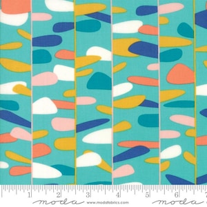 May include: A colorful fabric with a repeating pattern of abstract shapes in shades of blue, yellow, pink, and white on a teal background. The fabric has vertical stripes with a yellow border. The word "moda" is printed at the bottom.
