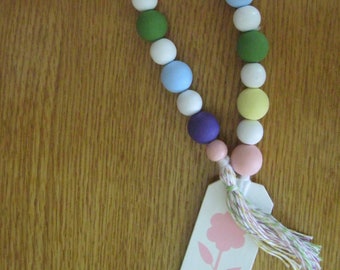 Spring Wood Bead Garland with flower tag and yellow, pink, white, green and purple beads tied up with a pastel tassel in time for Spring.
