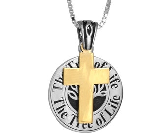 May include: A silver chain necklace with a pendant featuring a gold cross over a black circle with the words "The Tree of Life" inscribed around it.