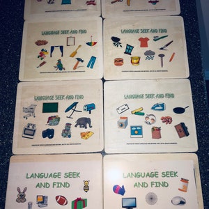 May include: Set of eight wooden game boards with colorful illustrations. Each board features the text "Language Seek and Find" and a variety of images to find.