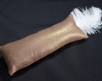 May include: A long, brown,  fabric cat toy with a white feather attached to one end.