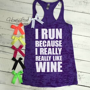 May include: Purple tank top with a distressed look and white text that reads "I run because I really really like wine".