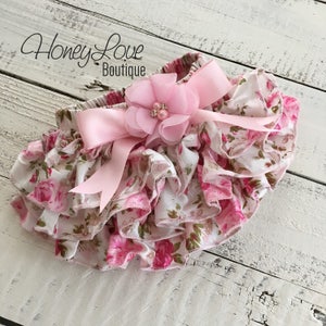 May include: Pink and white floral print baby bloomers with a pink satin bow and a pink flower embellishment.  Honey Love Boutique.