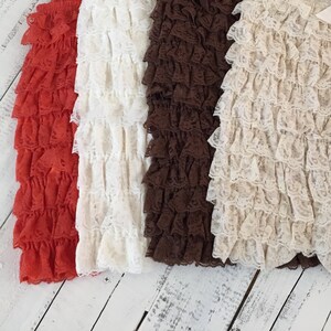 Op de afbeelding: Drie paar geruite kantleggings in rood, wit en bruin. De leggings zijn gemaakt van een zachte, rekbare stof en hebben een comfortabele pasvorm.