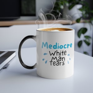 May include: White ceramic mug with a black handle. The mug has a blue and black design that says "Mediocre White Man Tears".