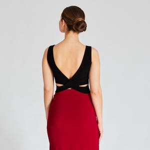 May include: A black sleeveless top with a criss-cross design in the back and a red skirt.