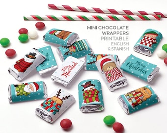 Könnte beinhalten: Mini-Schokoladenverpackungen mit weihnachtlichen Designs, darunter Schneemänner, Rentiere und der Weihnachtsmann, in verschiedenen Farben. Die Verpackungen haben einen türkisblauen Hintergrund mit weißen Punkten und den Text "Merry Christmas" und "Feliz Navidad".